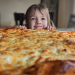 A little child smelling the fresh aroma of homemade pizza!