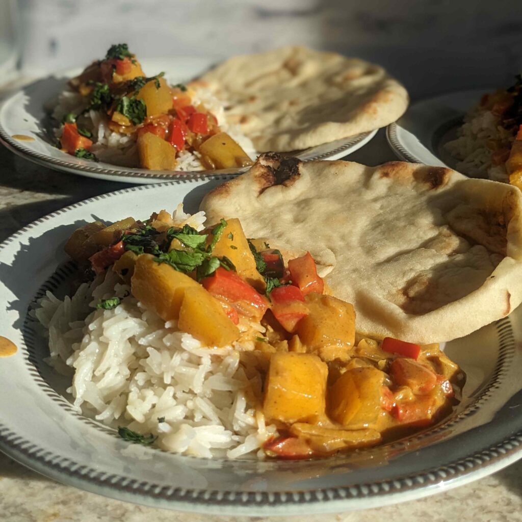 Quick and Easy Family Friendly Mango Curry Recipe. Plated with rice and naan bread on plate.