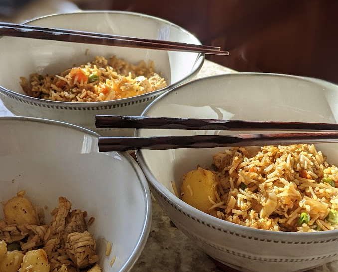 Bowls of steaming pineapple fried rice with chopsticks laying across the Bowl Top