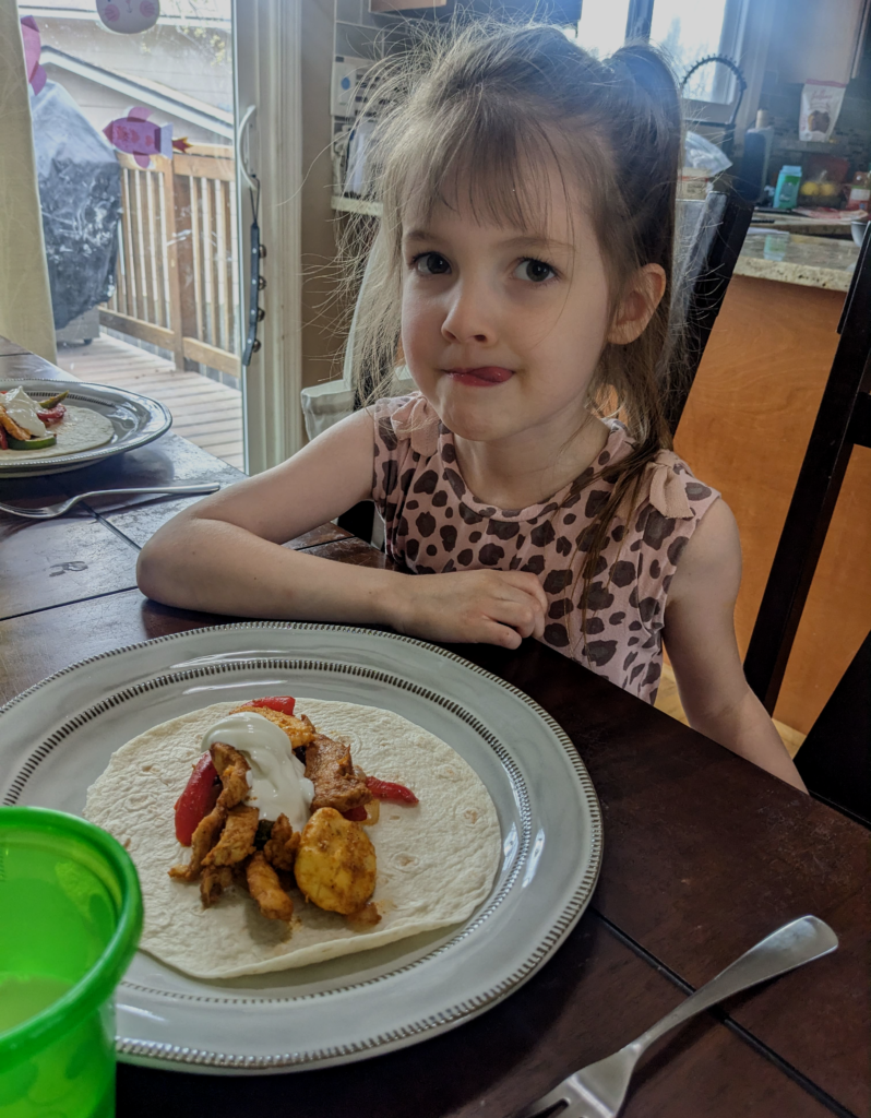 Little girl enjoying a delicious Chicken Fajita Plantain meal