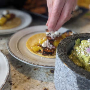 These delicious Al Pastor tacos are plated and served alongside guacamole in a molcajete.