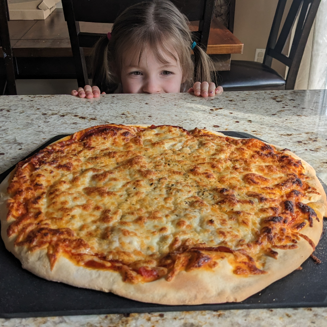 Little child looking over the counter to get a peak at this tasty pepperoni pizza! Featuring the gourmetguseats.com easy pizza dough recipe.