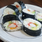 Plated Zesty california rolls featured in this Sushi Rice Recipe. Featuring vibrant red and orange pepper and creamy avocado.
