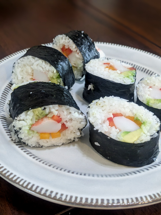 Plated Zesty california rolls featured in this Sushi Rice Recipe. Featuring vibrant red and orange pepper and creamy avocado.